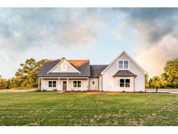 Charming two-story home featuring a covered porch and a well-manicured lawn at 269 Highway 11, Social Circle, GA 30025