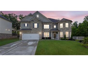 Beautiful two-story brick home featuring a two-car garage and lush green lawn at twilight at 4511 Bridgeway Rd, Atlanta, GA 30331