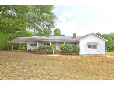 Charming single story home featuring a front porch and established landscaping in a lush green setting at 6191 Cumming Hwy, Canton, GA 30115