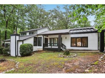 Charming home with black trim, white siding, and a well-maintained yard at 6700 Knollwood Cir, Douglasville, GA 30135