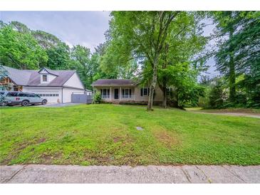 Charming single-story home with a welcoming front porch and a well-manicured lawn at 5310 Arrowind Nw Rd, Lilburn, GA 30047