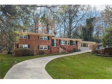 Charming red brick home featuring black shutters, mature trees, and a winding driveway at 1415 Dalewood Ne Dr, Atlanta, GA 30329