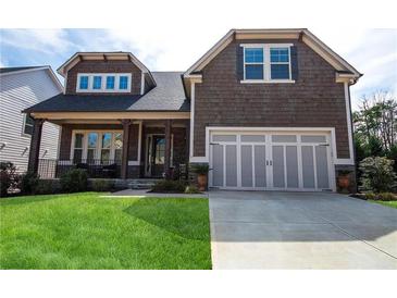 Charming two-story home featuring a well-manicured lawn, shingle siding, and an attached two-car garage at 322 Woodridge Pass, Canton, GA 30114