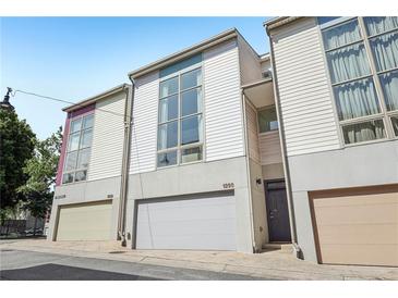 Contemporary townhome featuring a modern facade, individual garages, and large windows for natural light at 1290 Nervi Nw Mews, Atlanta, GA 30318