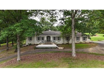 Charming brick home featuring a welcoming front porch and beautiful landscaping at 400 Simpson Ne Rd, White, GA 30184