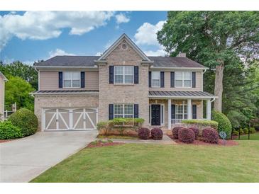 Charming two-story home with brick and siding, landscaped yard, and a two-car garage at 262 Sandhurst Ct, Suwanee, GA 30024