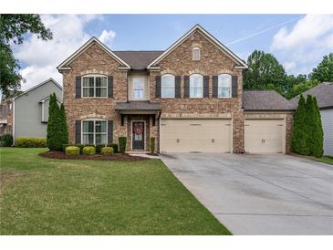 Stately two-story brick home with a three-car garage, well-maintained lawn, and mature landscaping at 4305 Hunters Walk Way, Cumming, GA 30028