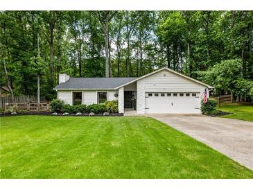 Charming single-story home featuring a lush green lawn, manicured landscaping, and an attached two-car garage at 171 North Trce, Alpharetta, GA 30009