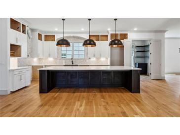Spacious kitchen with a large center island, custom cabinets, and modern pendant lighting at 2153 Cooper Lake Se Rd, Smyrna, GA 30080