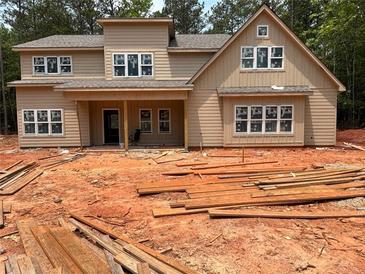New two-story home featuring large windows and a covered front porch in a partially wooded lot at 7947 Post Rd, Winston, GA 30187