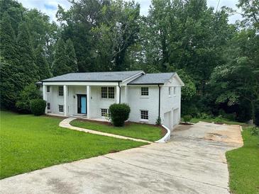 Charming two-story white brick home featuring a blue front door and well-manicured lawn at 1387 Renee Dr, Decatur, GA 30035