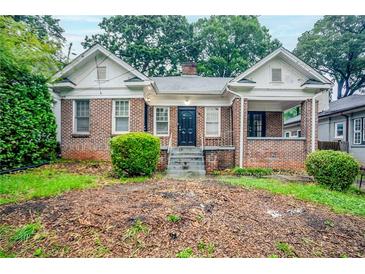 Charming brick home with covered front porch and landscaped yard at 1615 Stokes Sw Ave, Atlanta, GA 30310