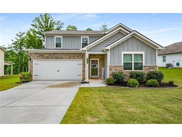 Charming two-story home with brick and gray siding, a well-manicured lawn, and a two-car garage at 510 Curry Ridge Ct, Locust Grove, GA 30248
