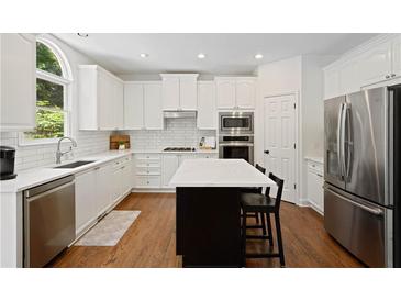 Bright kitchen with white cabinets, stainless steel appliances, and a large center island at 4108 Wyndam Hill Dr, Suwanee, GA 30024