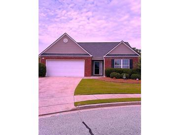 Charming single-story brick home featuring a two-car garage and manicured front lawn at 942 Village View Cir, Loganville, GA 30052