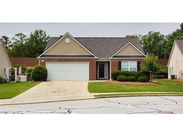 Charming single-story brick home with a manicured lawn and attached two-car garage at 942 Village View Cir, Loganville, GA 30052
