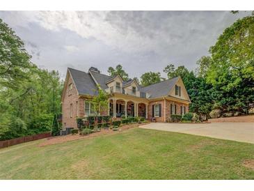 Elegant brick home with a manicured front lawn and inviting covered front porch at 95 Weslyan Way, Oxford, GA 30054