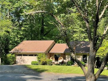 Charming single-story home with a lush green lawn and a welcoming front porch sitting area at 210 North Trce, Alpharetta, GA 30009