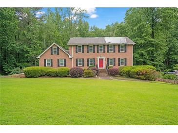 Traditional brick home with a manicured lawn and mature trees at 1777 E Gate Trl, Stone Mountain, GA 30087
