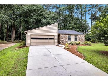 Charming single-story home featuring stone accents, an attached garage, and a well-maintained front yard at 2786 Olde Gate Ct, Snellville, GA 30078