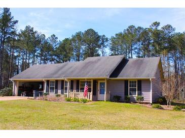 Charming single-story home with an attached garage, manicured lawn, and inviting front porch at 4841 Partee Trl, Social Circle, GA 30025