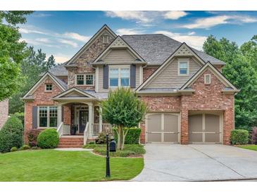Charming two-story home with a well-manicured lawn, stone and brick facade, and two-car garage at 3150 Seven Oaks Dr, Cumming, GA 30041