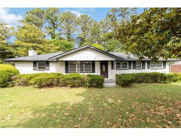 Charming, single-story home with white brick, black trim, and mature landscaping at 6873 Church St, Riverdale, GA 30274