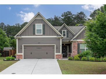 Charming Craftsman-style home with a well-maintained lawn, gray siding, brick accents, and an attached two-car garage at 2256 Long Bow Chase Nw, Kennesaw, GA 30144