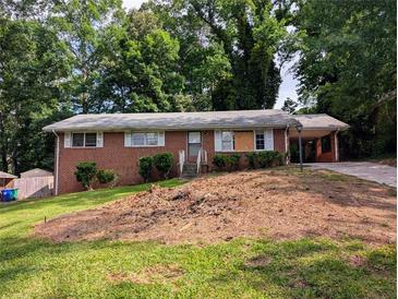 Charming brick home with a single-story layout and a cozy carport, nestled on a hill with mature trees at 3130 Gay Dr, Decatur, GA 30032
