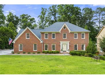 Beautiful two-story brick home with a well-manicured lawn and mature trees at 4343 Sprucebough Dr, Marietta, GA 30062
