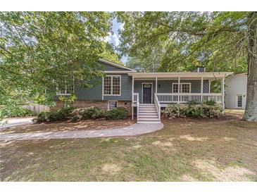 Charming home featuring a welcoming front porch, lush landscaping, and inviting curb appeal at 3404 Broxton Mill Way, Snellville, GA 30039