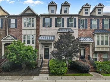 Charming townhome with brick facade, manicured landscaping, and inviting front entrances at 3386 Vintage Se Cir # 8, Smyrna, GA 30080