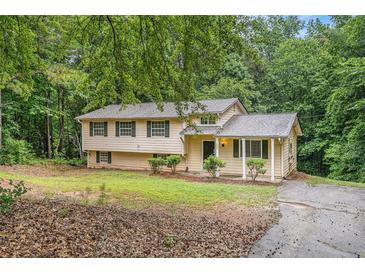 Charming two-story home with a cozy covered porch and a well-maintained lawn surrounded by mature trees at 1034 Sandy Ridge Rd, Mcdonough, GA 30252