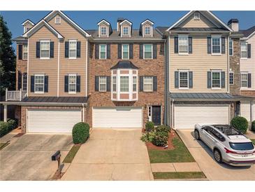 Charming townhome with attached garages, neat landscaping and neutral-colored exterior at 6004 Turfway Park Ct, Sugar Hill, GA 30518