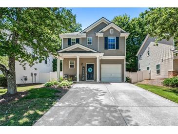 Charming two-story home with a well-maintained yard, covered front porch, and single-car garage at 130 Nacoochee Way, Canton, GA 30114