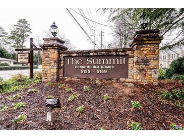 Stone entrance sign for The Summit Condominium Homes featuring landscaped flower beds and available homes signage at 5157 Roswell Rd # 1, Atlanta, GA 30342