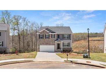 Charming two-story home with brick and gray siding, complemented by a well-manicured lawn at 620 Lobelia Way, Locust Grove, GA 30248