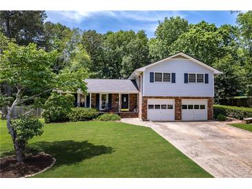 Charming split-level home with a well-manicured lawn and a two-car garage, nestled in a wooded area at 5778 Little Oak Trl, Stone Mountain, GA 30087