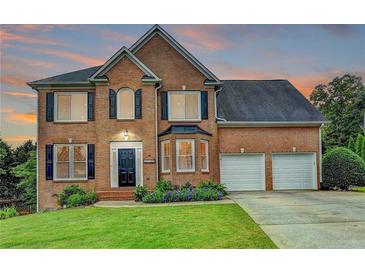 Charming two-story brick home with a well-manicured lawn and a two-car garage, located in a suburban neighborhood at 3760 Ansley Park Dr, Suwanee, GA 30024
