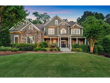 Charming two-story home with a combination of stone and siding, complemented by lush landscaping and a well-manicured lawn at 1220 Waterfall Nw Ln, Acworth, GA 30101
