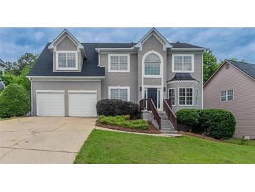 Charming two-story home with a well-manicured lawn, two-car garage, and a classic gray stucco facade at 1706 Brandon Lee Sw Way, Marietta, GA 30008