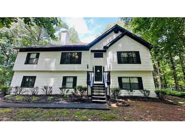 Charming two-story home featuring a symmetrical facade, black shutters, and lush landscaping at 2985 Heather Stone Way, Lawrenceville, GA 30043