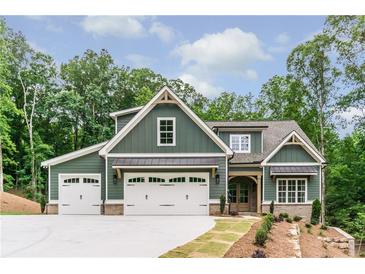 Charming home showcasing a welcoming three-car garage and a beautifully landscaped front yard at 7080 Driskell Cir, Cumming, GA 30041