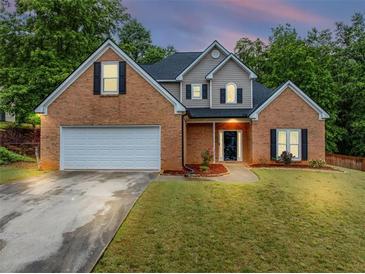 Charming two-story brick home with manicured lawn and attached two-car garage at 3190 Water Brook Sw Dr, Conyers, GA 30094