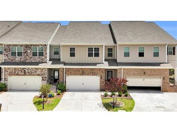 Charming townhome exteriors with brick and stone accents and two-car garages at 2340 Manor Pointe Dr, Cumming, GA 30041