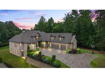 Beautiful brick home featuring manicured landscaping, three-car garage, basketball court, and brick and stone accents at 241 Russell Rd, Lawrenceville, GA 30043