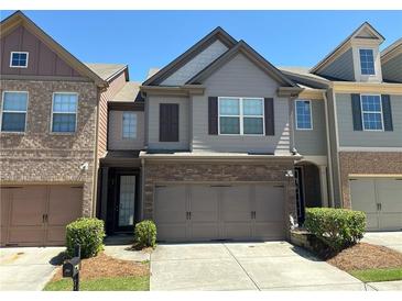 Two-story townhouse with a two-car garage, neat landscaping, and stone and siding exterior at 2351 Attewood Dr, Buford, GA 30519