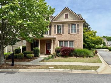 Charming brick home with a well-manicured lawn and a welcoming red front door at 4916 Gathering Pl, Suwanee, GA 30024