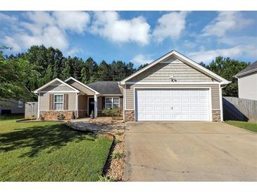 Charming one-story home featuring stone accents, neutral siding, and a well-manicured lawn with an attached two-car garage at 109 Rockefeller Ln, Dallas, GA 30157