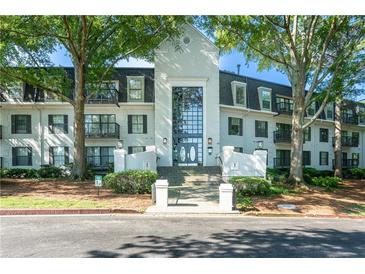 Attractive condo building exterior with mature trees, well-maintained landscaping, and covered entrance at 1105 Pine Heights Ne Dr, Atlanta, GA 30324